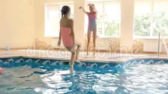 4K镜头少女与朋友玩耍将她推入游泳池视频的预览图