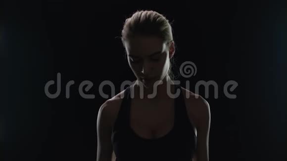 微笑的女人在健身房锻炼哑铃健身女孩在运动锻炼中微笑视频的预览图