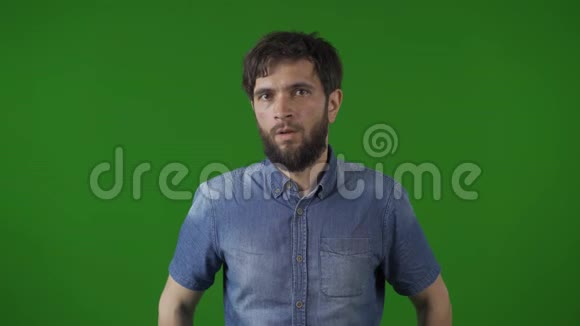 一个不确定的人的肖像显示了我不知道的情绪在缓慢的运动挥动他的头否在绿色的屏幕上视频的预览图