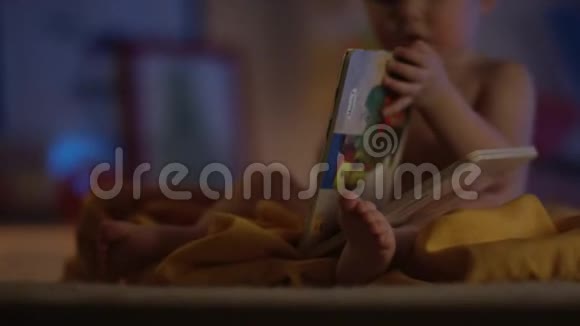 可爱的宝宝只是坐在不好的地方玩一本书并展示如何阅读与专注的书视频的预览图