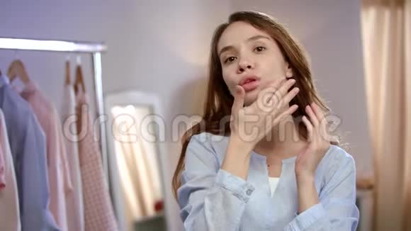 年轻女子面对护肤把漂亮女孩的脸用乳液贴紧视频的预览图