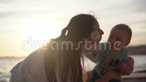 妈妈吻了一个婴儿在大海附近表现出一些热情动作缓慢视频的预览图