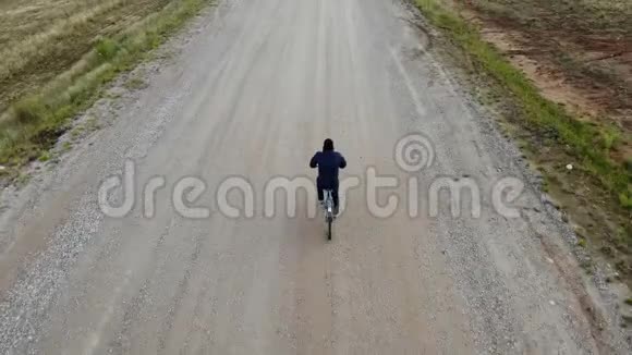 骑自行车的公路自行车骑自行车的人从顶部鸟瞰从上面射击人骑自行车在空路上视频的预览图