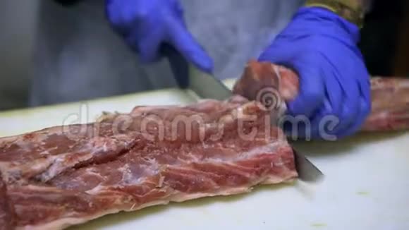 4K屠夫在商店修剪猪肉腰部用刀子在杂货店切肉视频的预览图