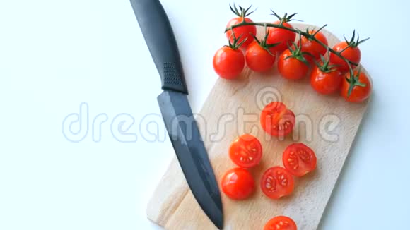 时尚的陶瓷菜刀和成熟的红色小樱桃番茄成串部分切在视频的预览图