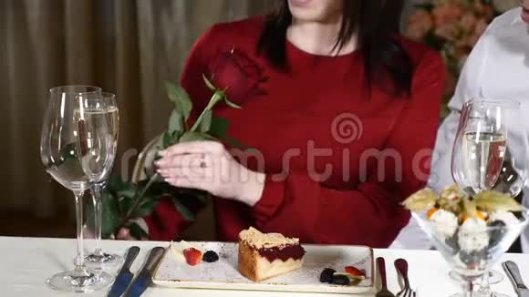 恋爱2月14概念年轻迷人的女人拿着一朵红玫瑰男人的气味年轻的情侣约会视频的预览图