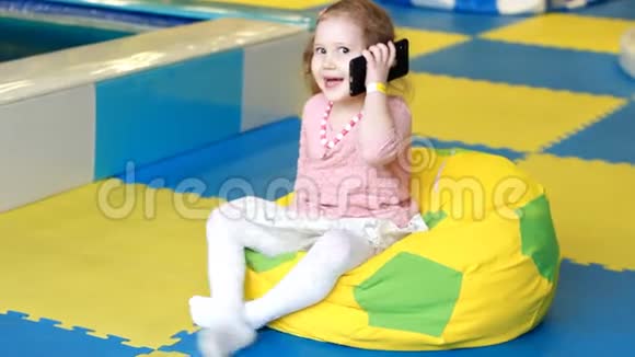 小女孩在用手机说话孩子手中的新数字技术有智能手机的小孩画像视频的预览图