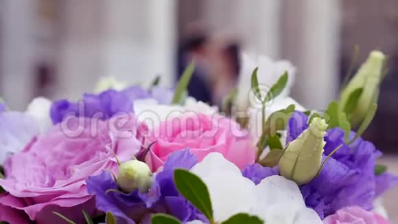 新娘花束在前台与新娘和新郎在软焦点背景视频的预览图