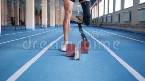 带假肢的短跑运动员站在起跑线上近距离视频的预览图