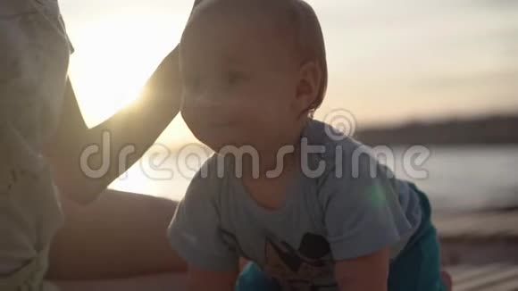 妈妈在日落时慢动作地抚摸一个美丽快乐的婴儿视频的预览图