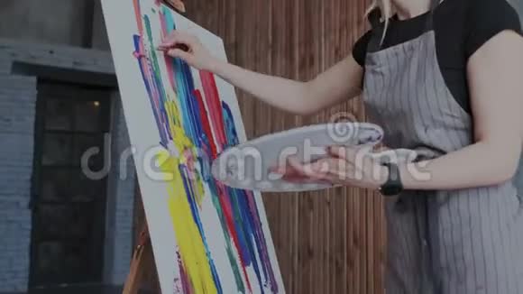 表达你的创造力积极的年轻女人一边画画画架一边享受她的爱好采用多色油漆视频的预览图