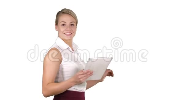 女办公室职员带着平板电脑走路在白色背景上与摄像机交谈时笑容满面视频的预览图