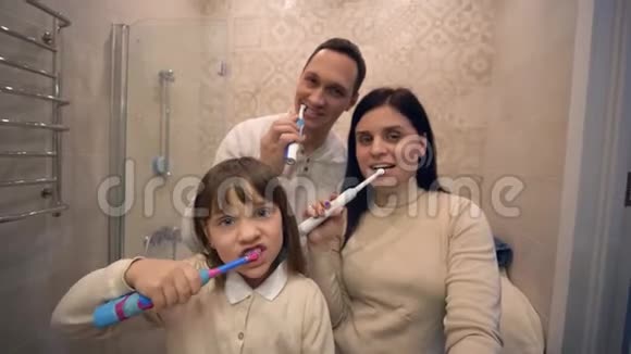 牙齿护理幸福家庭用牙刷在镜子前刷牙视频的预览图