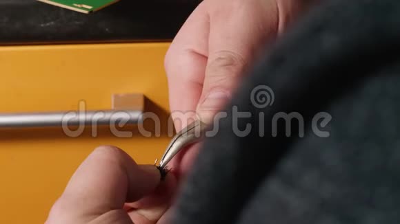 男人手焊按钮到电卡近距离观看人类手中的家用设备视频的预览图