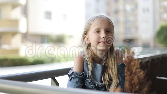 夏天漂亮的女学生坐在阳台上视频的预览图