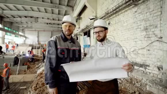 两名戴防护头盔的男子在施工区域一起工作工人在后台焊接领班视频的预览图