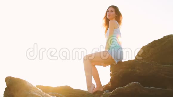 那个女孩坐在海里的岩石上视频的预览图