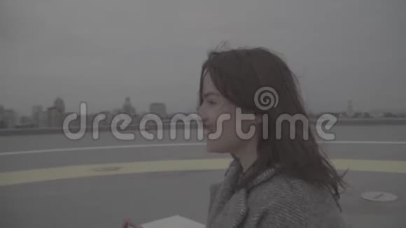 穿灰色外套的可爱女孩坐在室外的莲花位置Slog视频的预览图