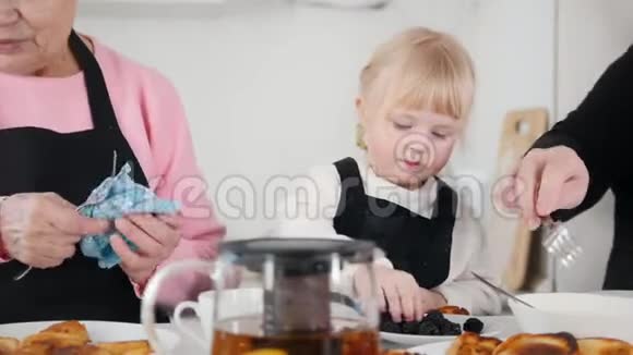 家人吃煎饼喝茶小女孩吃黑莓视频的预览图