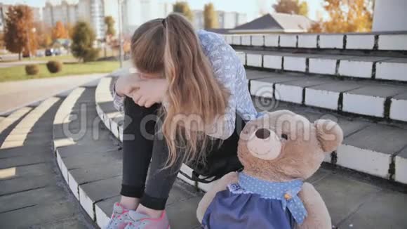 带着玩具熊在户外哭泣的少女视频的预览图