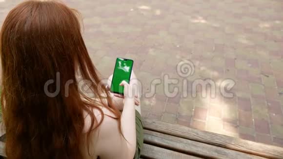 公园里的女孩在社交网络上交流阳光明媚的长凳上视频的预览图