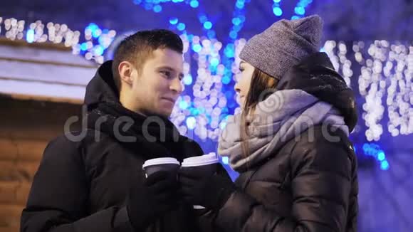 快乐的年轻夫妇在圣诞集市上喝咖啡美丽的家庭令人心寒圣诞快乐新年快乐视频的预览图