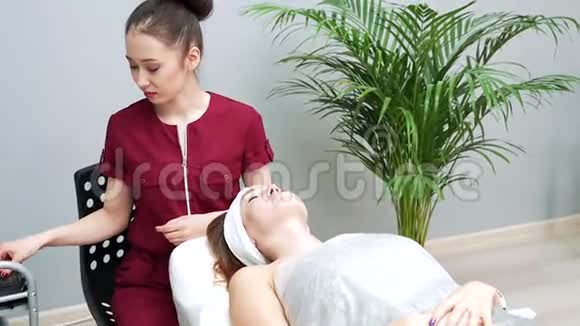 年轻的亚洲女性美容师戴着医用口罩和手套准备美容手术视频的预览图