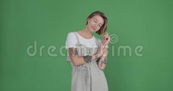 在绿色背景下穿着长袍的纹身女人视频的预览图