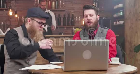 穿着时髦西装留着漂亮胡子的男人正在非正式的环境中举行视频会议视频的预览图