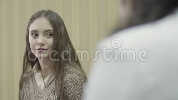 一位留着长发的年轻漂亮女孩在内阁中与医生协商时的打扮视频的预览图