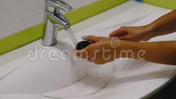 慢动作木刷女人在洗手池里用肥皂和泡沫洗脏化妆刷视频的预览图