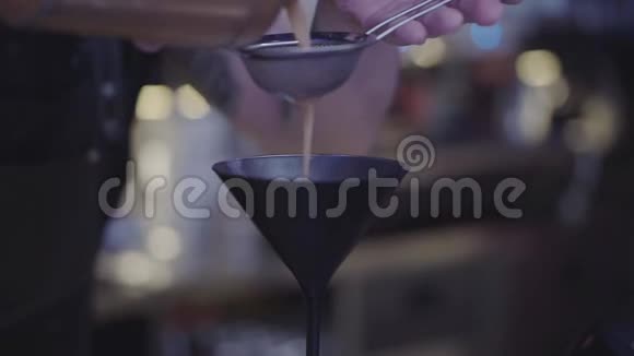 未识别的调酒师的手通过鸡尾酒杯内的染色剂注入液体联合调酒师视频的预览图