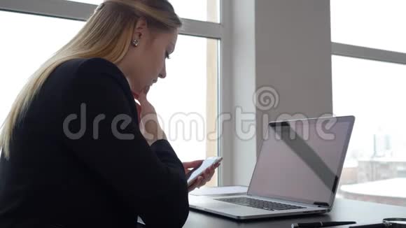 女企业家在办公桌上使用智能手机和笔记本电脑视频的预览图