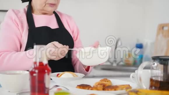 吃煎饼的老妇人在薄煎饼上放酸奶油视频的预览图