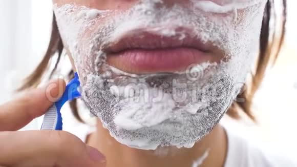 带泡沫和手动刮胡子的男人视频的预览图