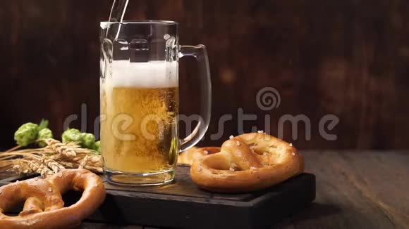 啤酒正倒入一个杯子里在木桌上放点啤酒视频的预览图