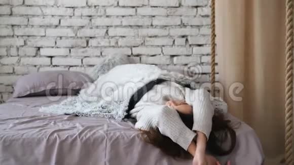 玩的年轻女人在家里的床上玩得开心视频的预览图