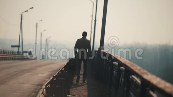 在桥上行走的年轻人汽车在路上行驶早晨和雾春天视频的预览图