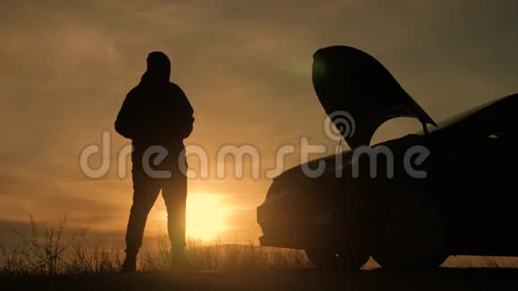 日落时剪影人正站在那辆破车旁边视频的预览图