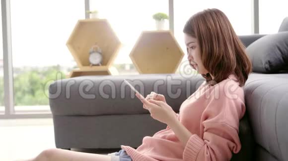 快乐女性使用平板电脑在家里发短信阅读观看视频和上网生活方式女性在家里的概念视频的预览图