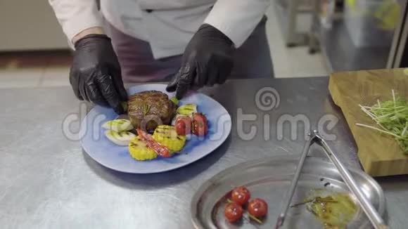 餐厅厨师的双手装饰着美味的牛排玉米柠檬草番茄樱桃和铃铛片视频的预览图