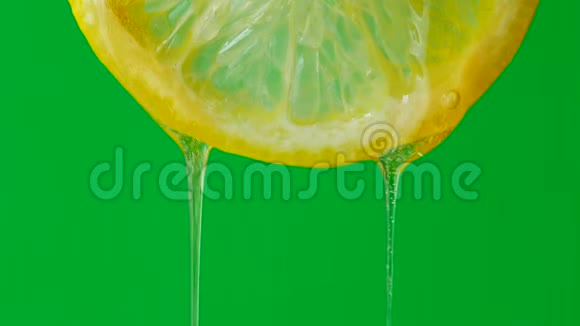 在绿色背景下滴上半个柠檬的蜂蜜视频的预览图