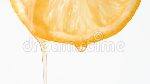 在白色背景下滴着半个柠檬的蜂蜜视频的预览图
