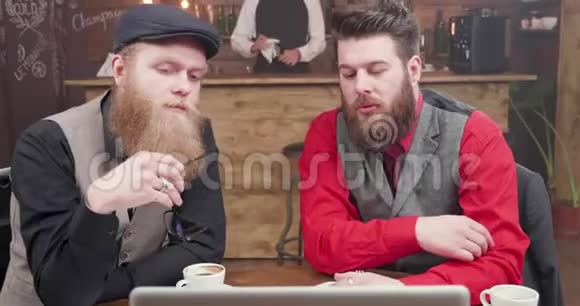 与两个留胡子的家伙在老式酒吧举行非正式商务视频会议视频的预览图
