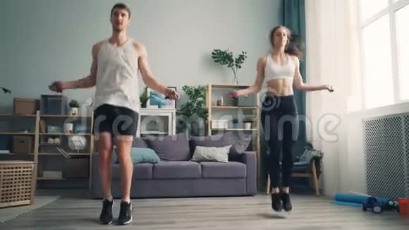 男女青年夫妇在家里跳绳一起在室内做运动视频的预览图