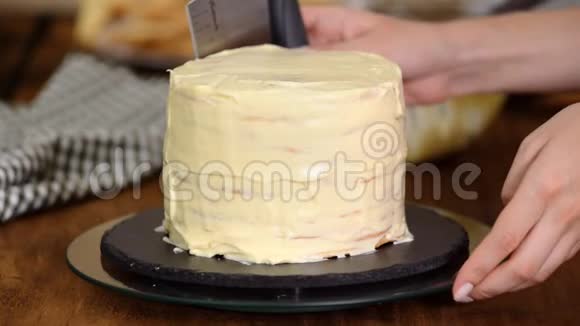 在家里做一层层的拿破仑蛋糕用奶油蛋糕和洒布做成圆形的分层拿破仑蛋糕的过程视频的预览图