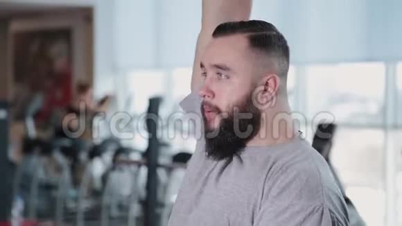 英俊的运动员在健身房训练三头肌和哑铃视频的预览图