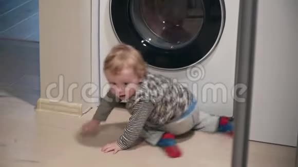一岁男孩在家看洗衣机小男孩关上洗衣机视频的预览图