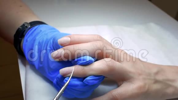用专业的金属指甲剪把手从女性指甲中取出角质层健康的女人手视频的预览图