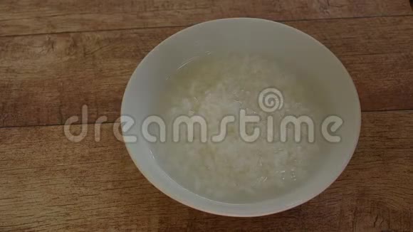 用银勺舀半切的咸蛋放在碗里煮米饭上视频的预览图